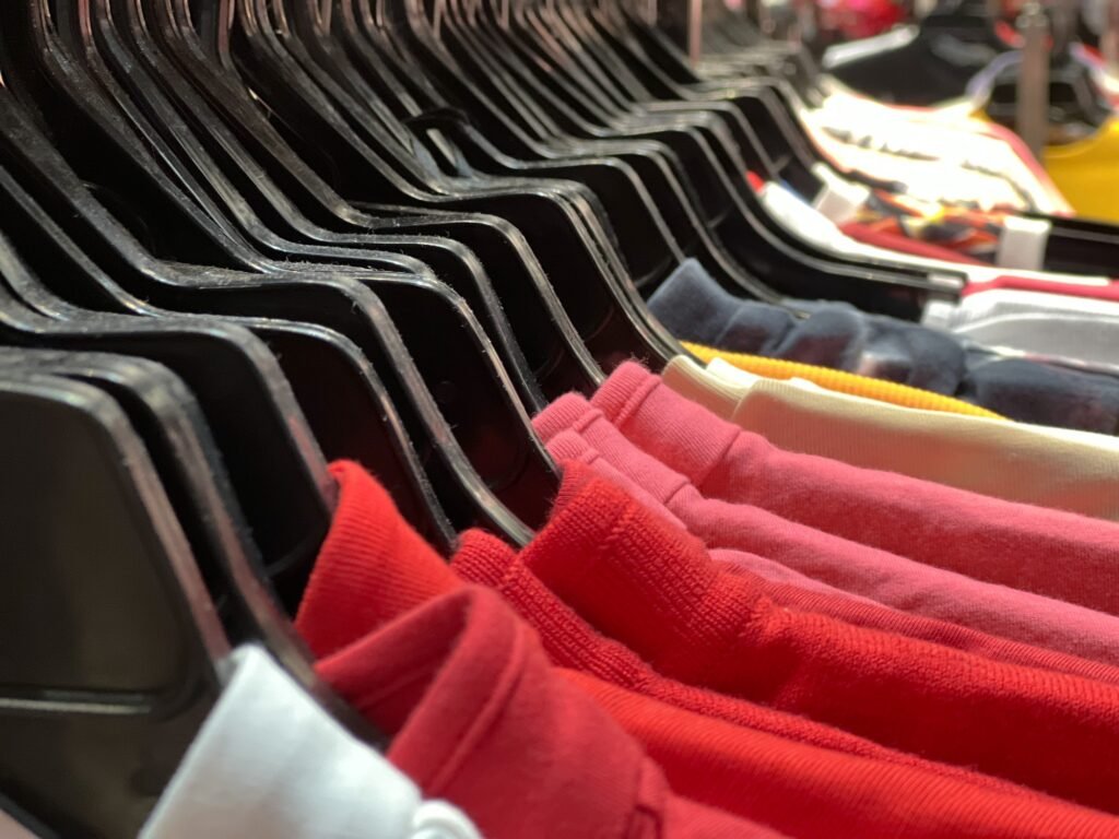 Closeup group of colorful t-shirt hanging on the rack for sole in the shop