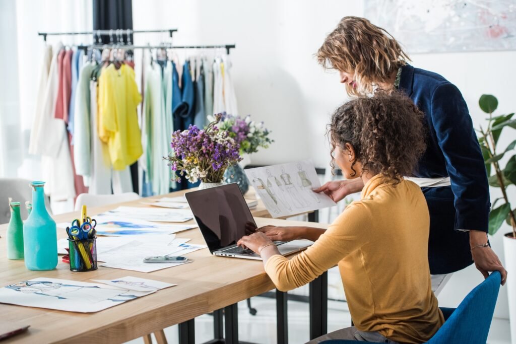 young multiethnic fashion designers using laptop with blank screen